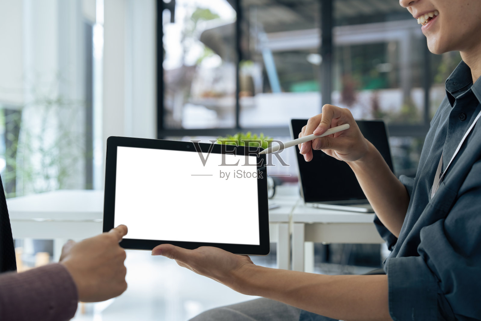 两个学生在客厅的桌子边学习时，拿着黑色的平板电脑和空白的桌面白屏的模拟图像照片摄影图片