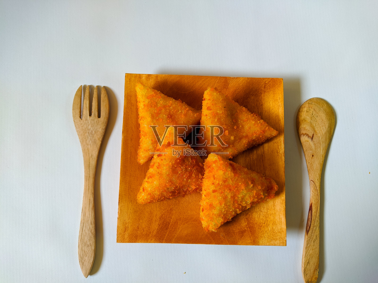 risole或rissole是裹着面包屑的小馅饼。通常夹着蛋黄酱和香肠。用木盘子盛的照片摄影图片