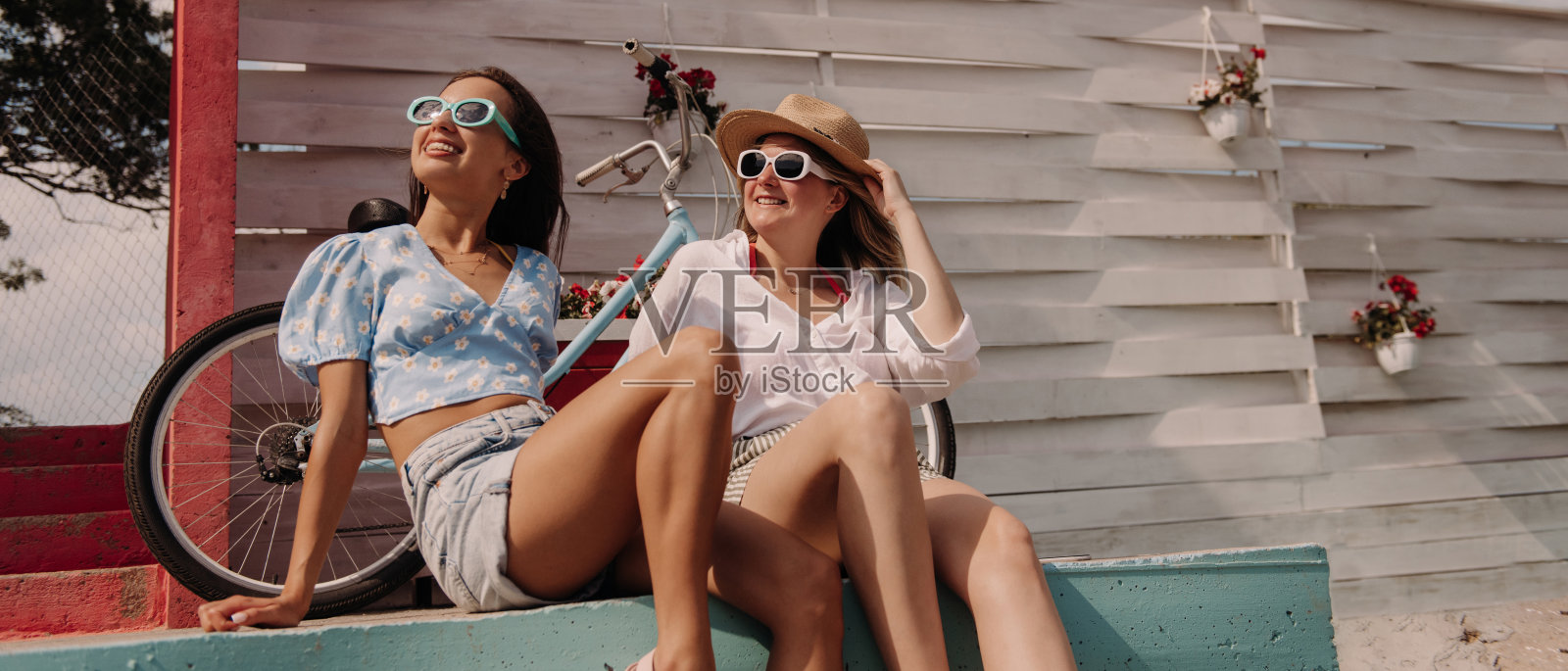 两个美丽的年轻女子看起来很放松，一起享受夏日的户外照片摄影图片