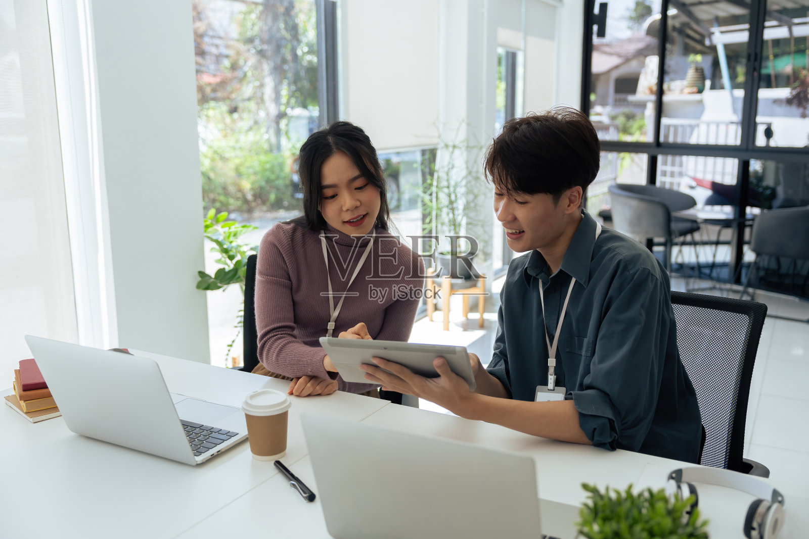 在办公室里，员工们一起在桌上的笔记本电脑上讨论头脑风暴，规划业务战略照片摄影图片