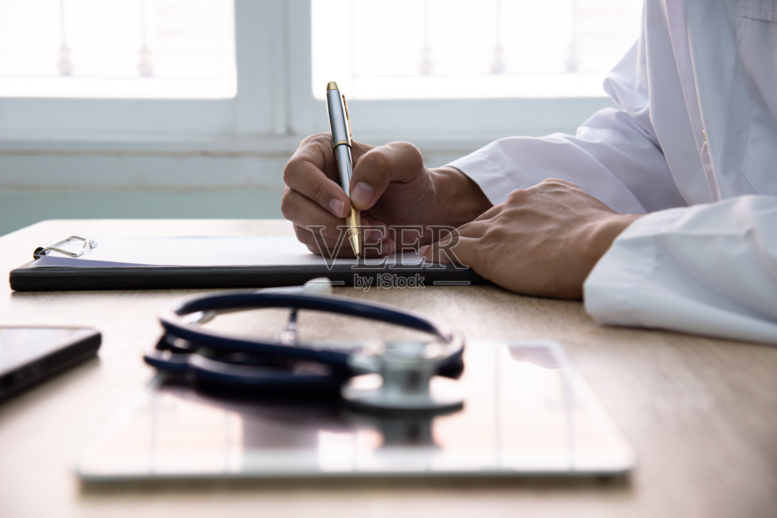 医生在医院开药方。照片摄影图片