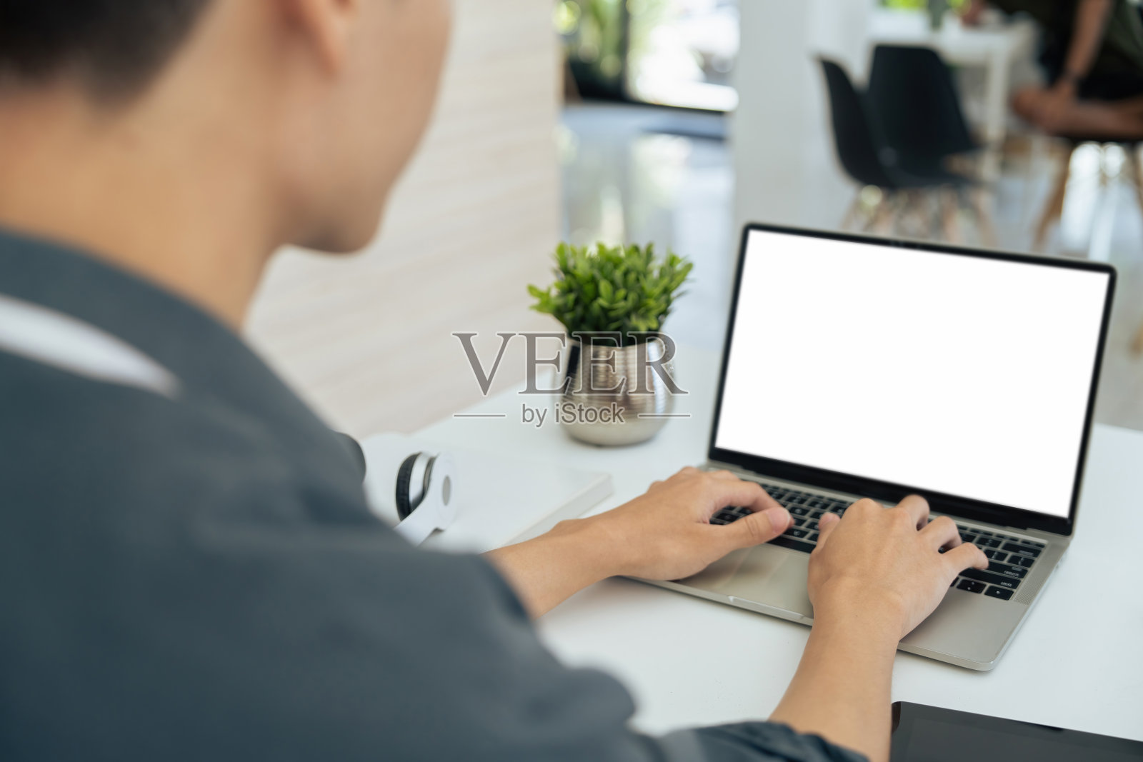 特写:年轻的商人坐在办公桌前，用笔记本电脑工作。在办公桌前工作的员工。空白屏幕照片摄影图片