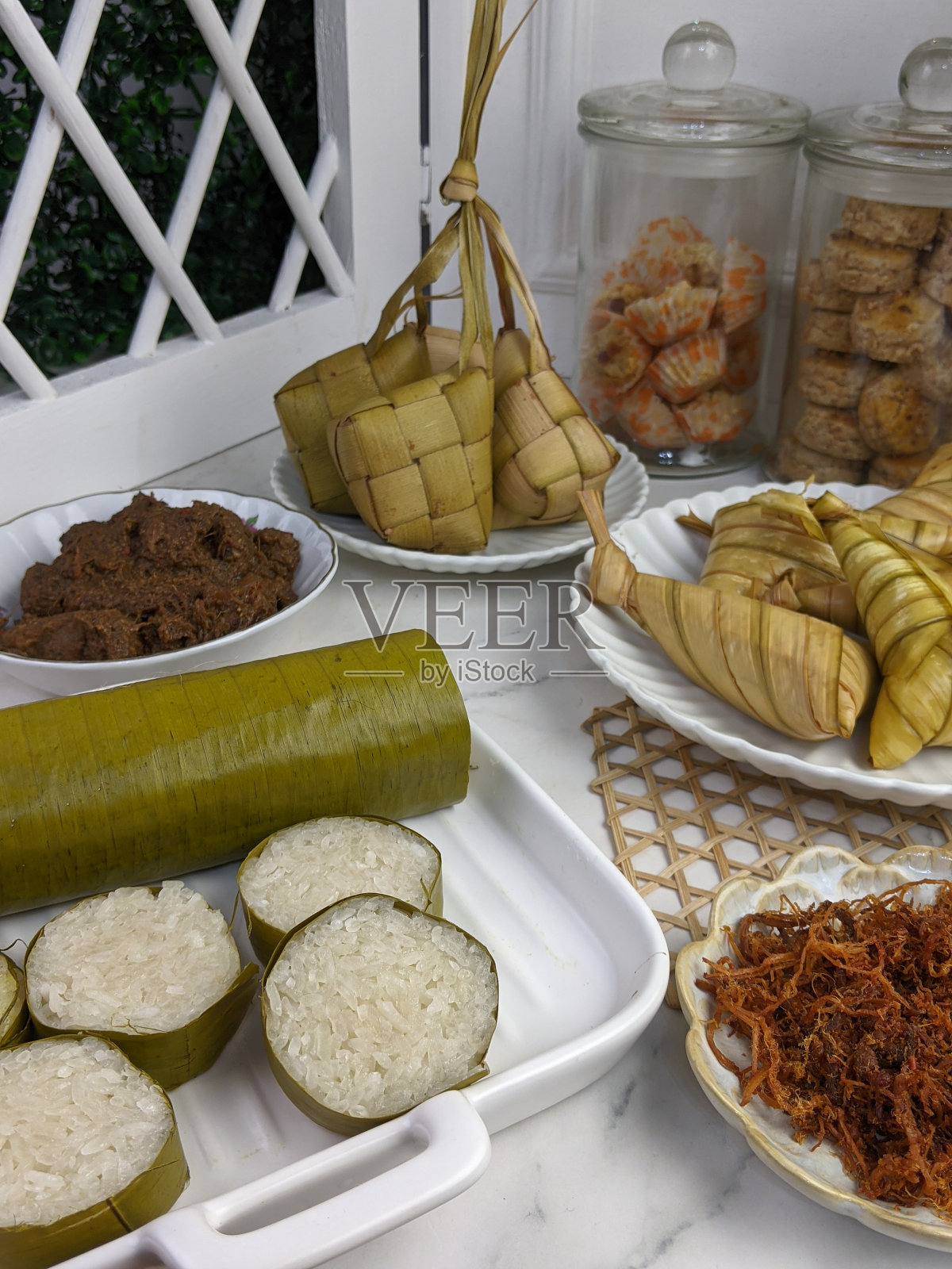 马来西亚开斋节传统穆斯林食物：马来粽、糯米饭、仁当、肉松和卡江酱，称为Juadah Raya照片摄影图片