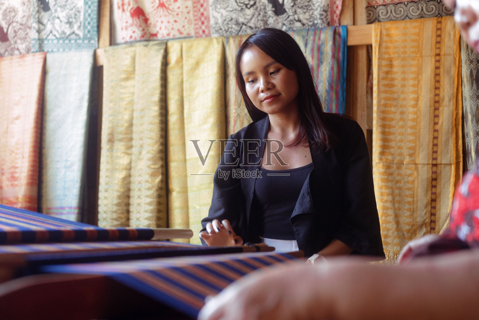 美丽的亚洲女人学习手工制作传统编织Tenun布照片摄影图片