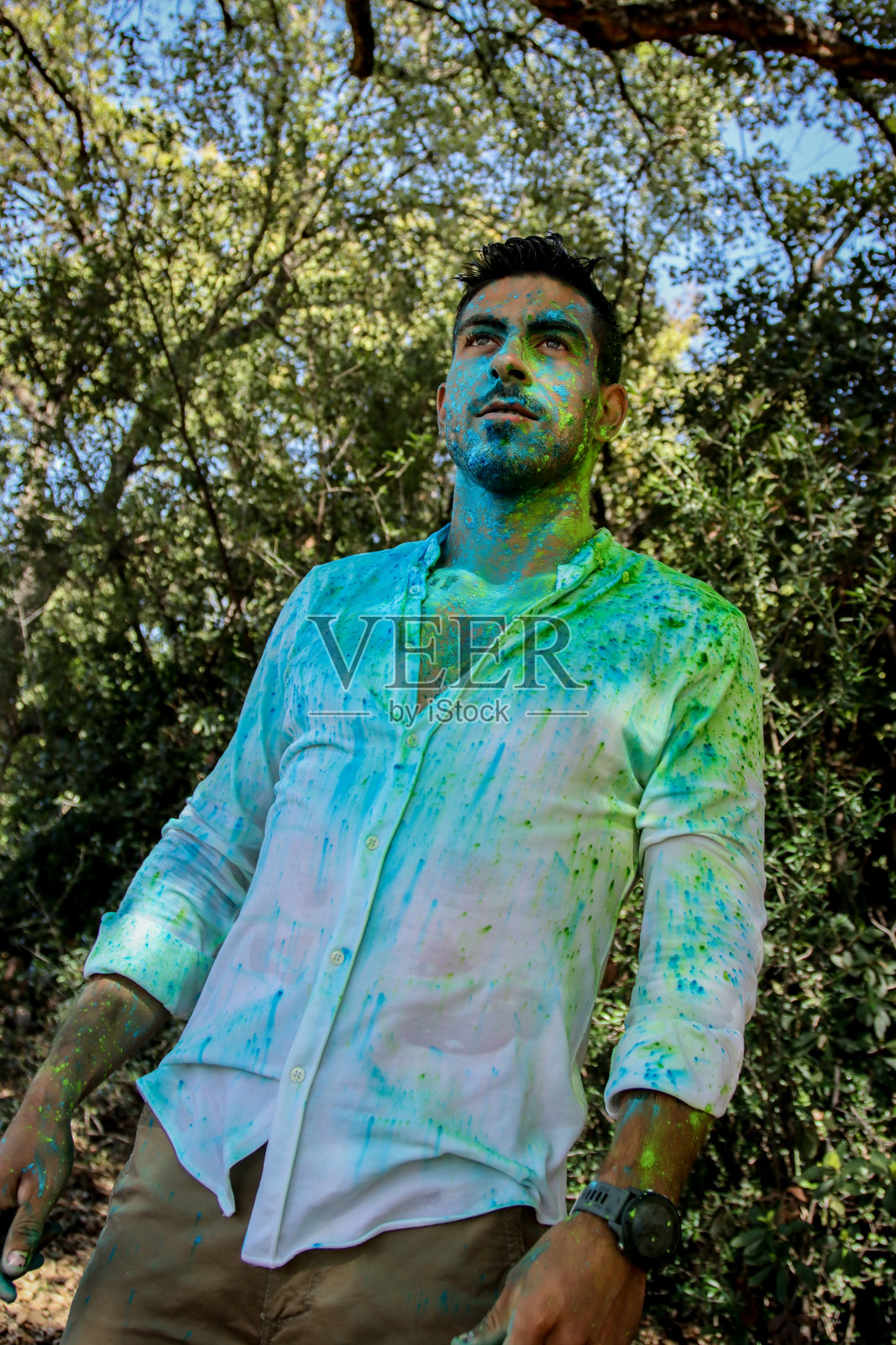 在公园里，一个浑身是胡里节粉末的年轻人照片摄影图片