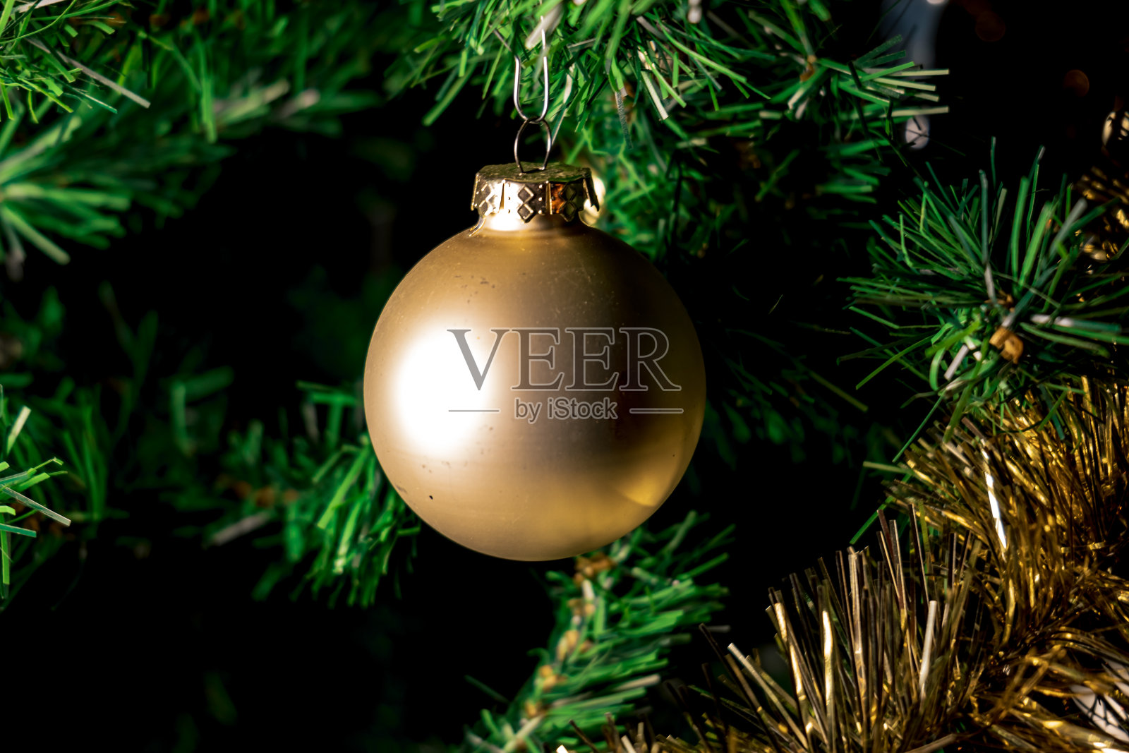 人造树上的圣诞球。装饰圣诞树的特写。光反射在金色的圣诞球上照片摄影图片