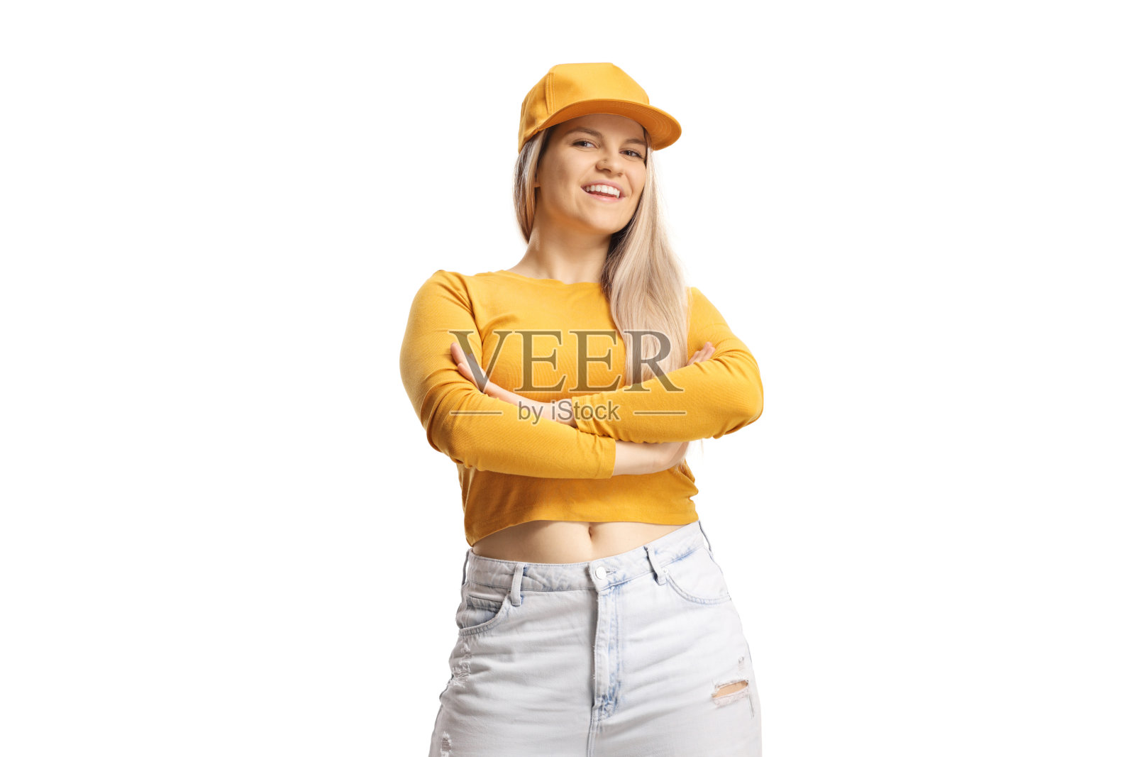 戴着帽子和黄色上衣的年轻女性在摆姿势照片摄影图片