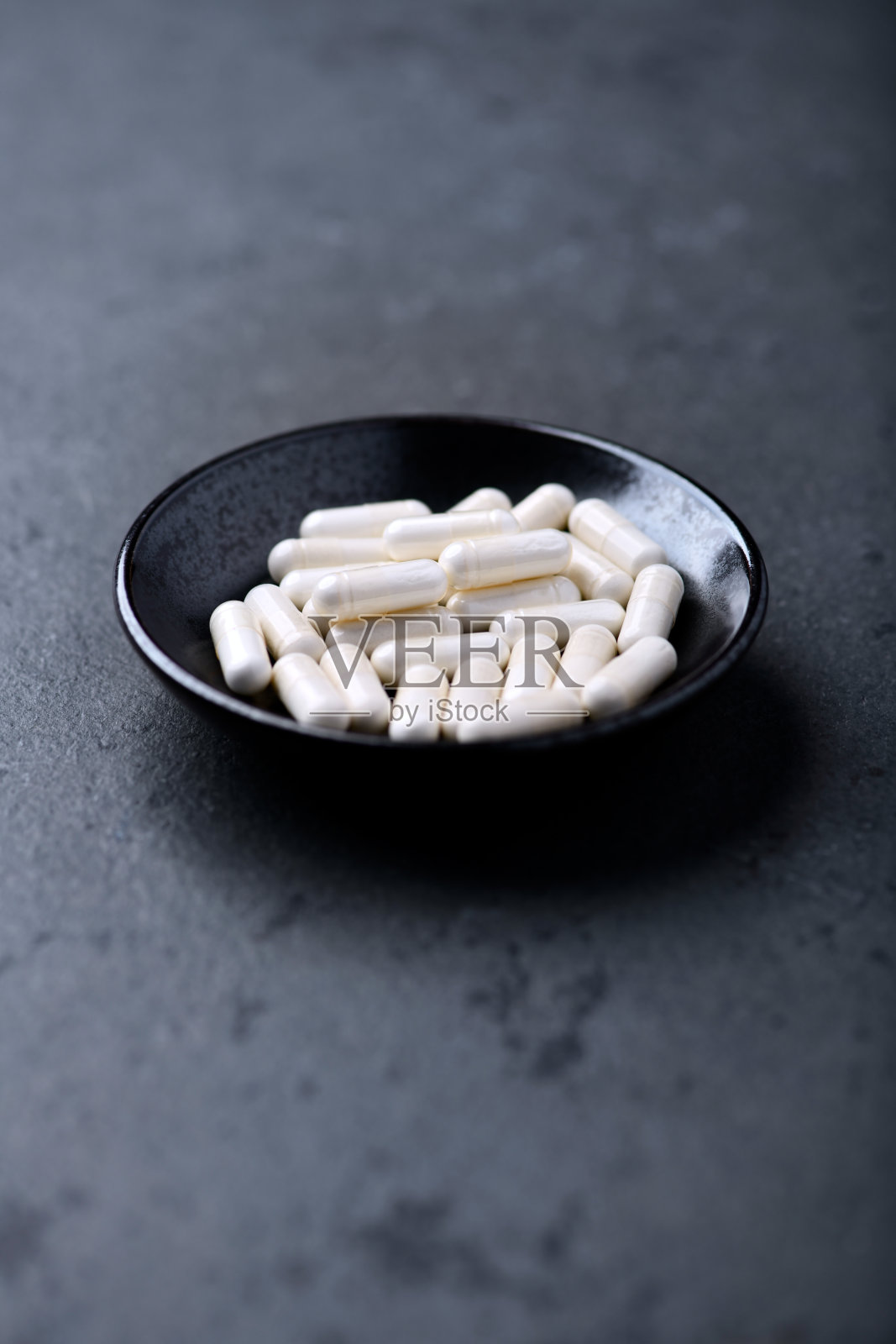 锌胶囊在黑暗的石头背景。软的焦点。副本的空间。照片摄影图片