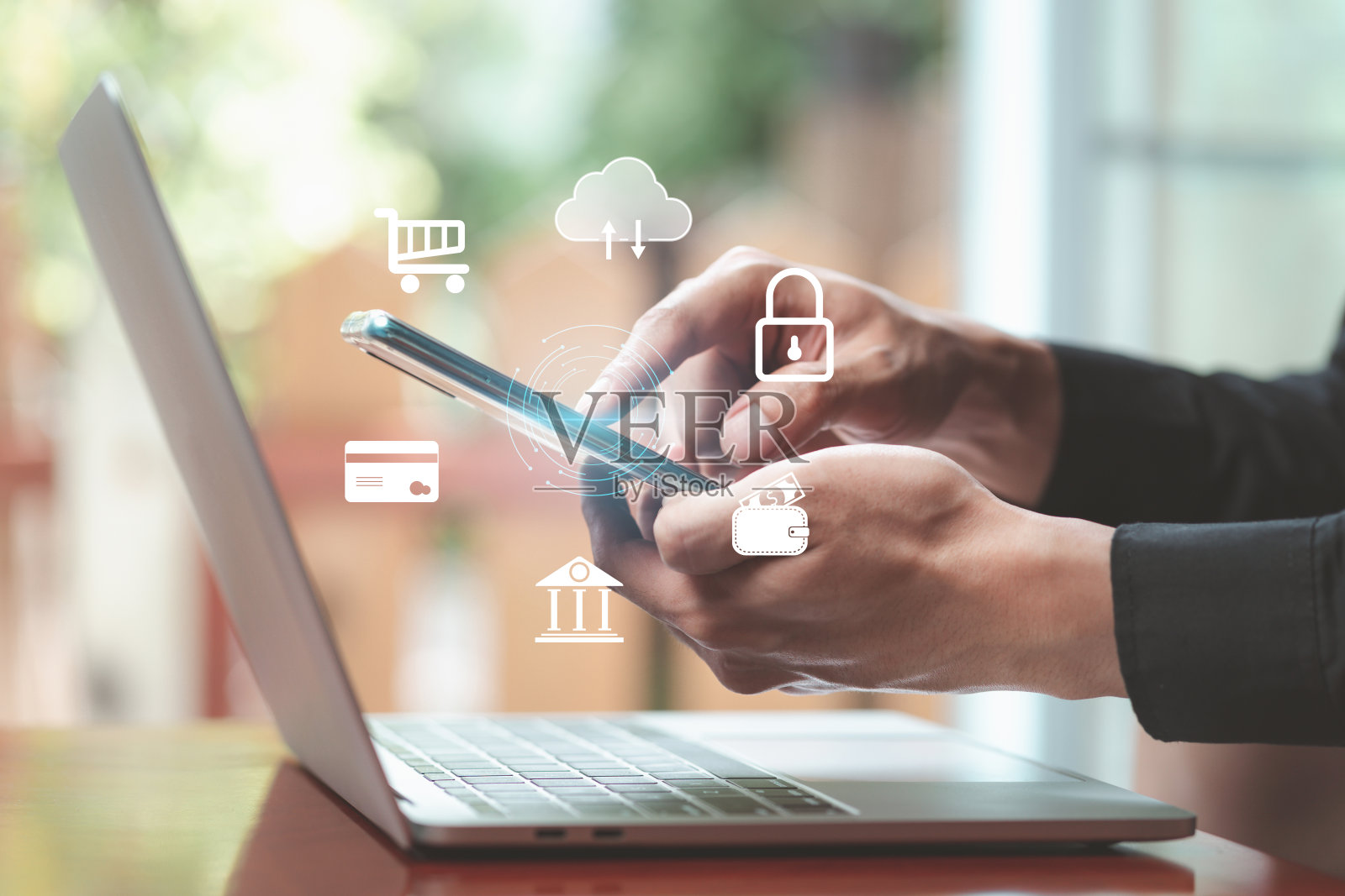 使用智能手机通信和应用程序。男子在桌上用手提电脑玩手机。信息与通信，金融交易，备份，网上购物，安全，数据分析照片摄影图片