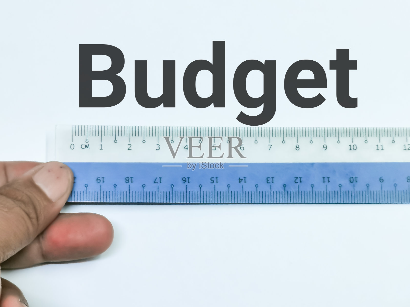 用塑料尺子在白底上作文字预算。照片摄影图片