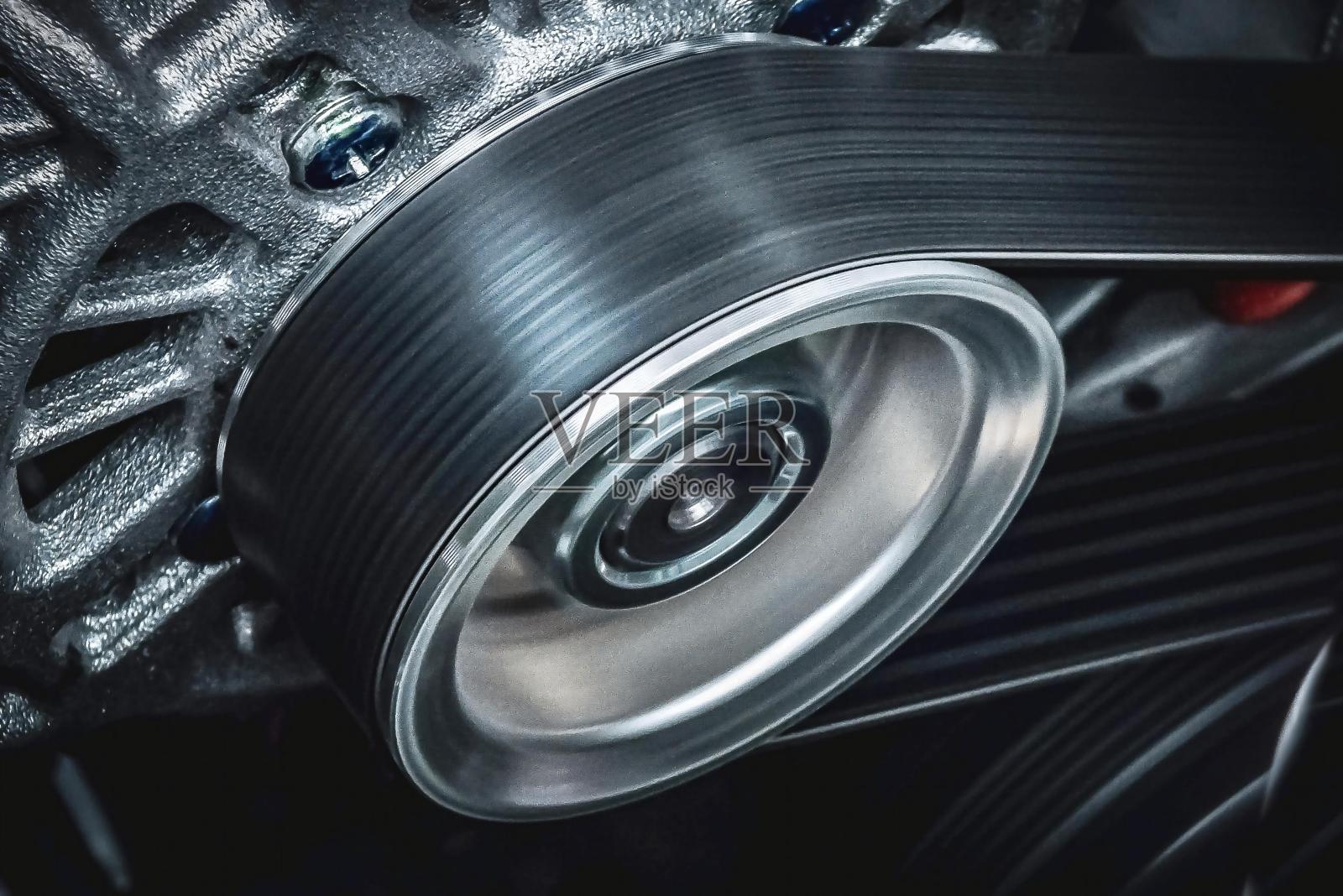 汽车发动机皮带的特写照片，带传动的汽车发动机上的机油滤清器。照片摄影图片