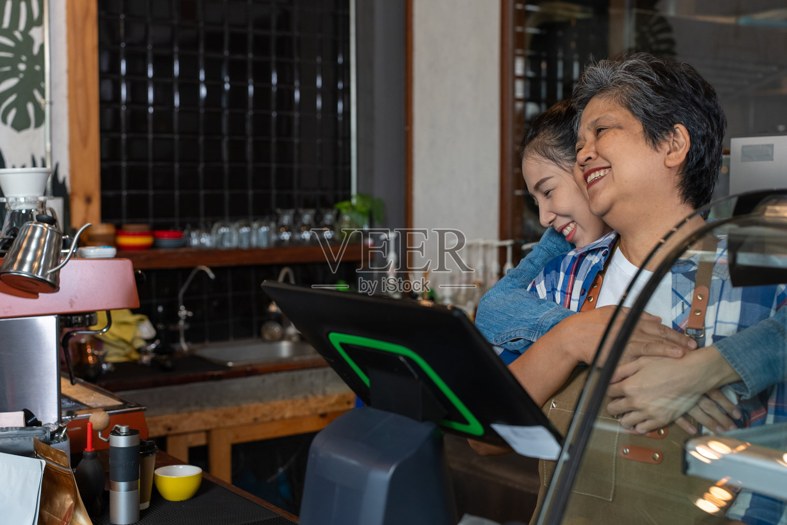 亚洲可爱的老人，老人，退休，女人。母亲和女儿在她的咖啡店工作。小企业，企业主。照片摄影图片