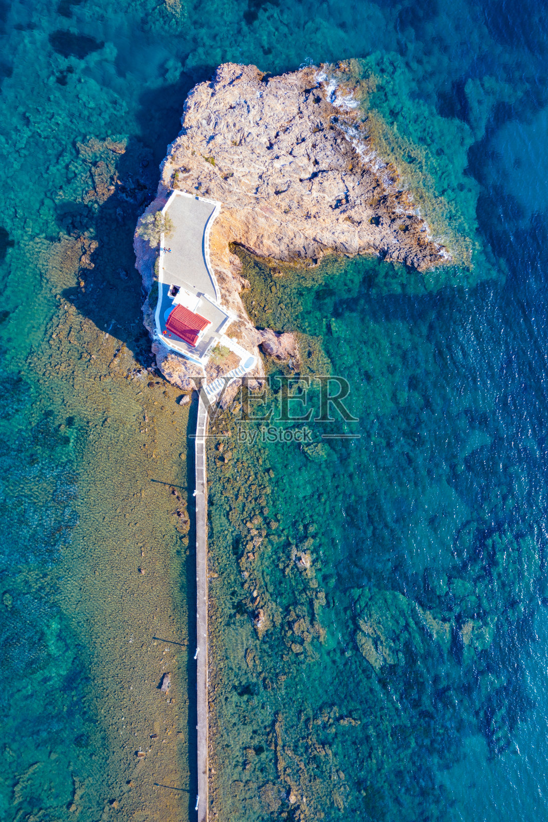 希腊莱罗斯岛岩石上方的海上阿吉奥斯·伊西多罗斯小教堂。照片摄影图片