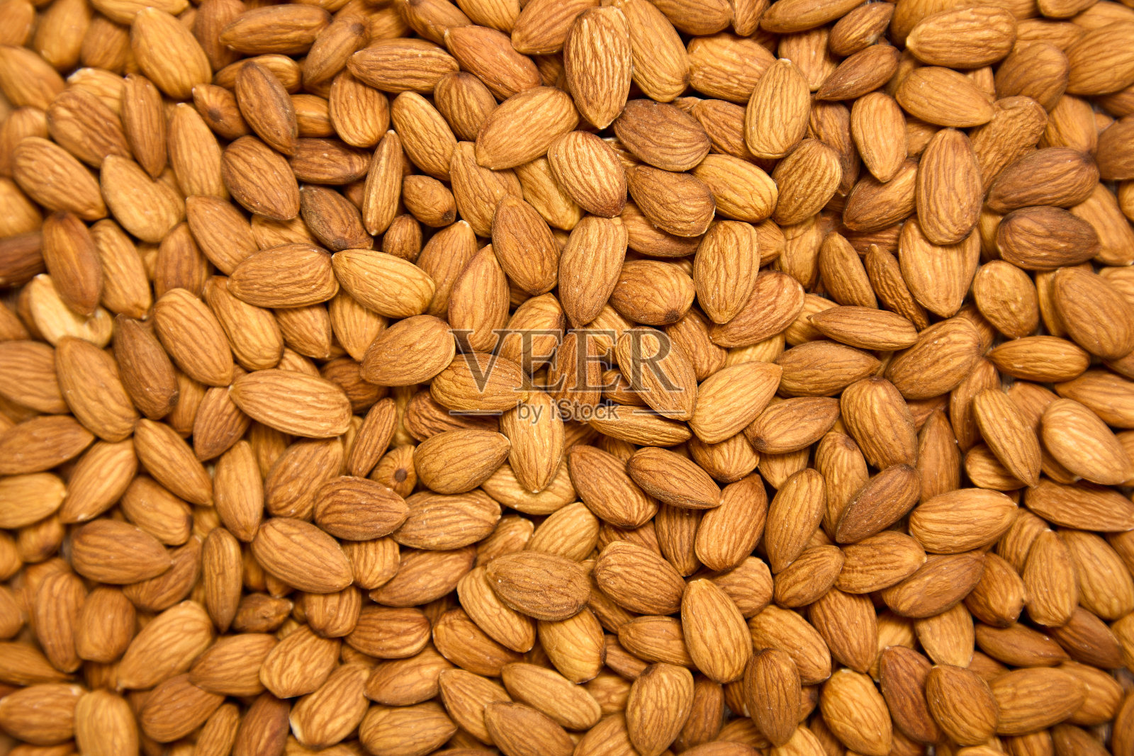 背景是棕色的大生去皮杏仁，随意排列照片摄影图片