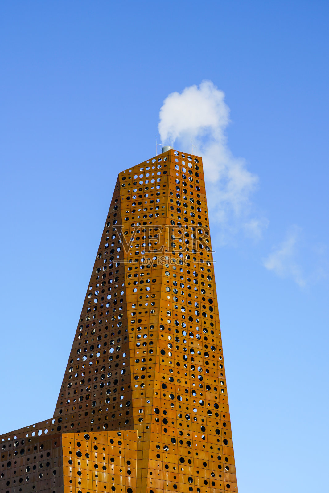 丹麦罗斯基勒的垃圾焚烧和回收工厂烟囱，蓝天背景。照片摄影图片