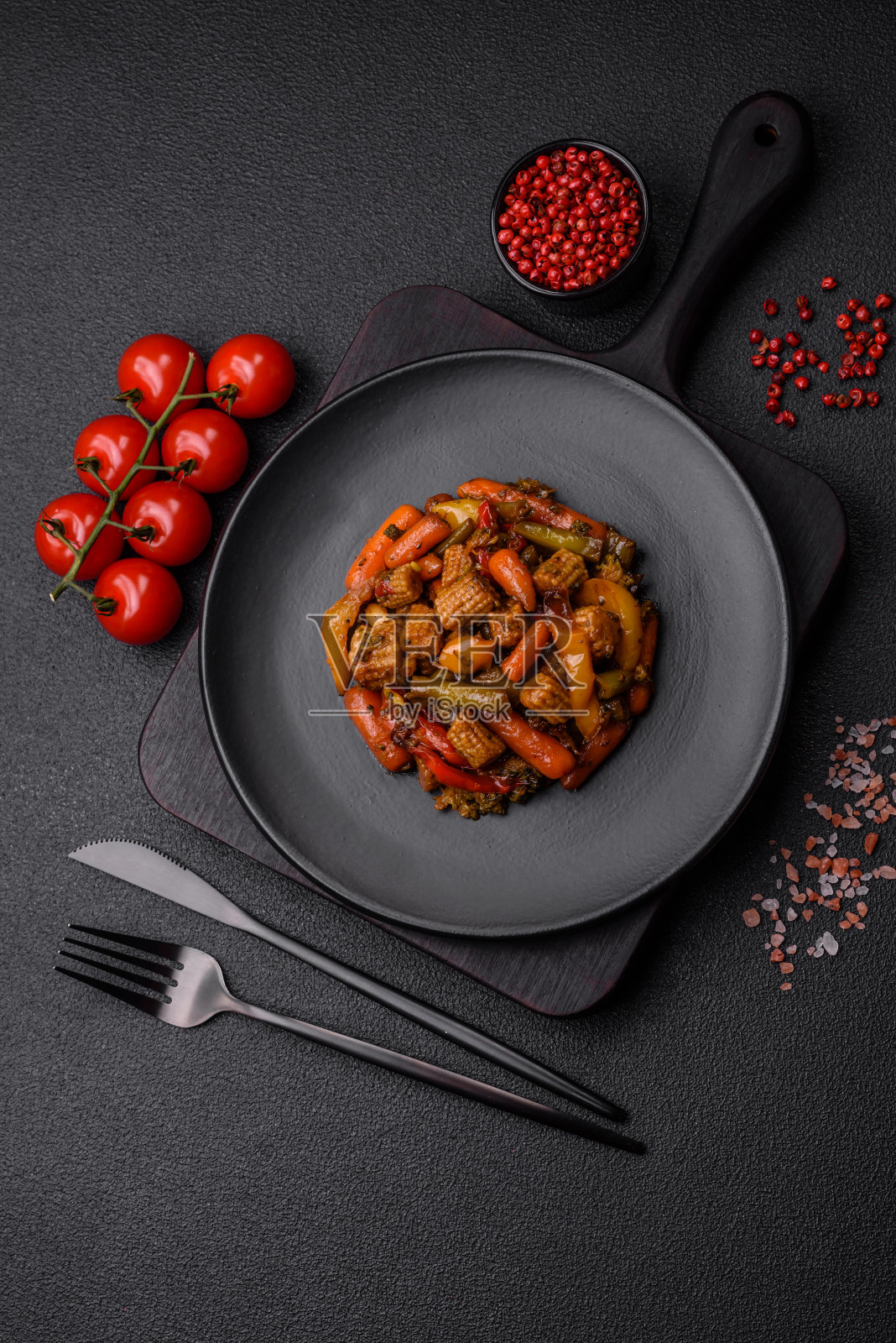 把蔬菜，玉米，胡萝卜，辣椒，西兰花，洋葱和照烧酱混合在陶瓷盘子里照片摄影图片