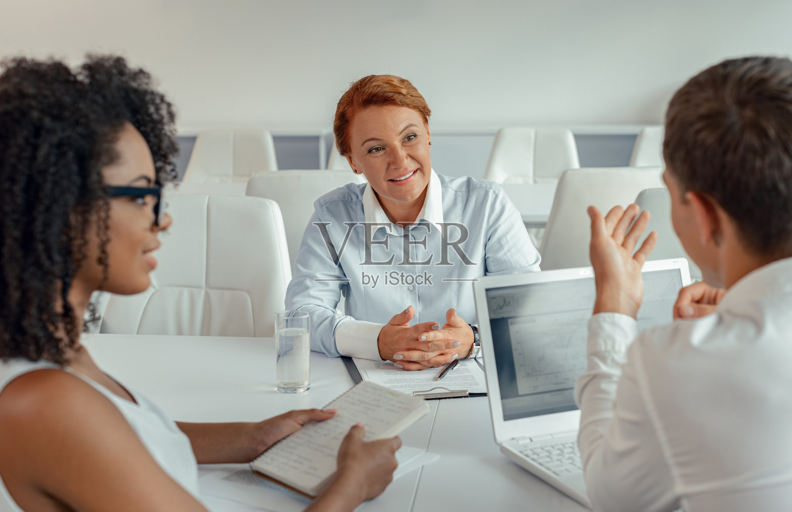 女商人的肖像，听她的员工坐在她面前照片摄影图片