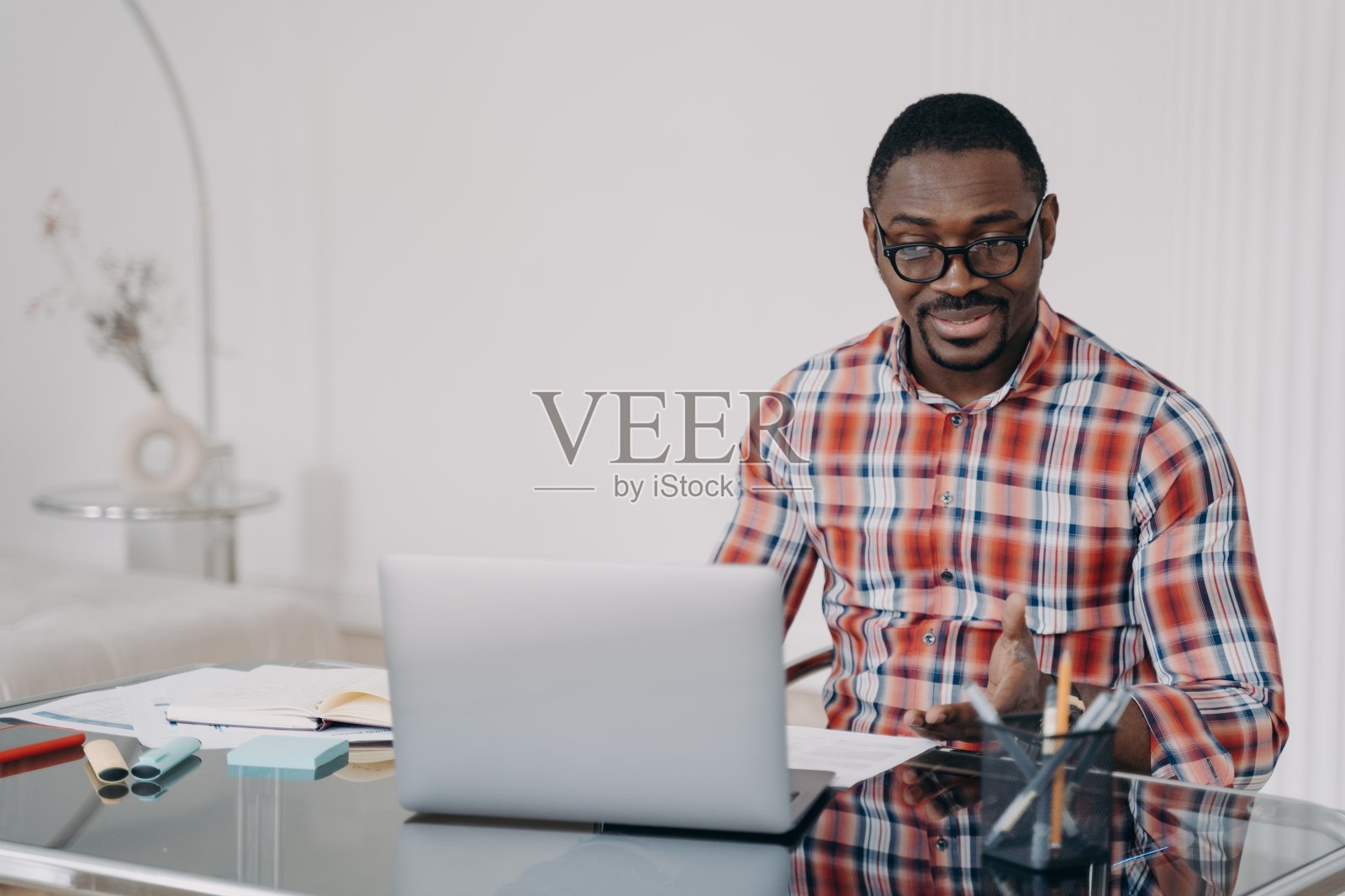 困惑的非洲裔美国人看着笔记本电脑屏幕。糟糕的网络连接。远程工作的问题照片摄影图片