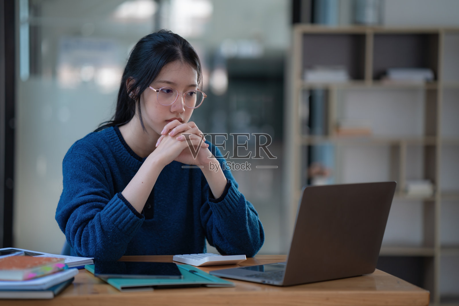 压力很大的年轻女商人，头疼在办公室用笔记本电脑工作。照片摄影图片