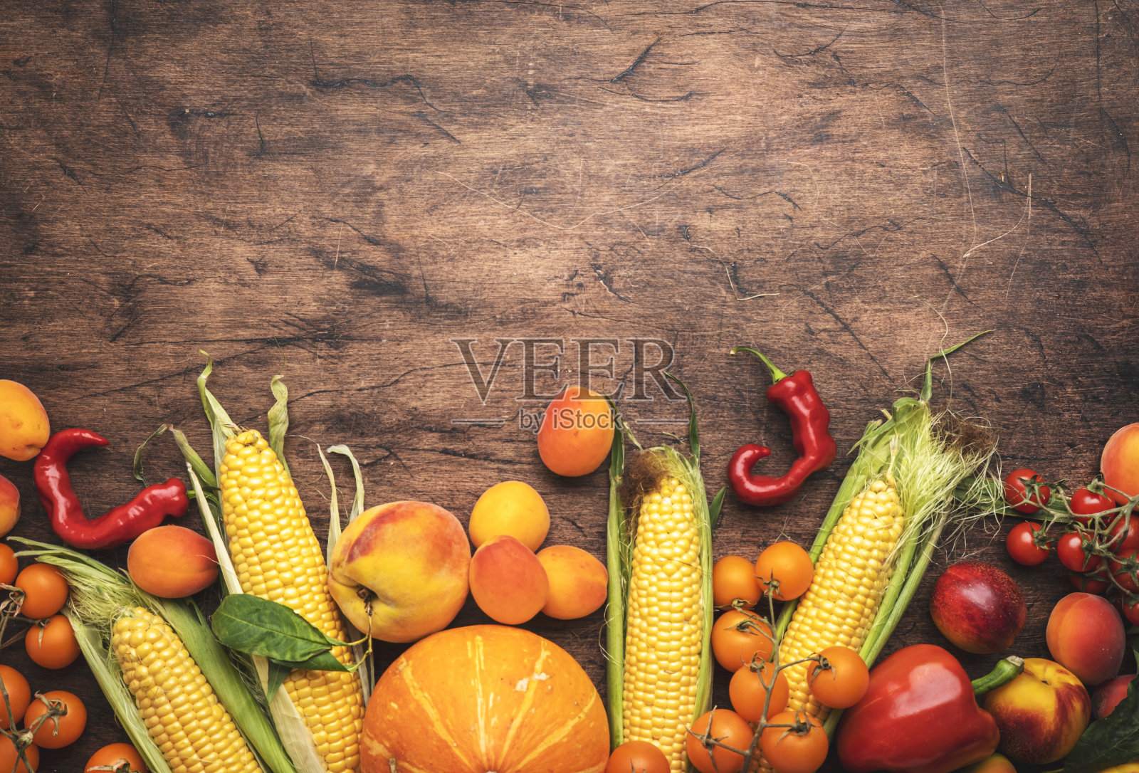 秋季橙色、黄色、红色的蔬菜和水果集，杏、圣女果、南瓜、玉米等在质朴的木制背景上，俯视图照片摄影图片