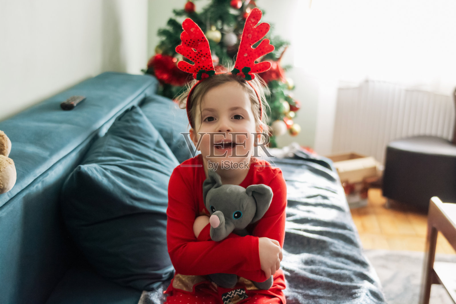 圣诞节期间，可爱的女孩在家里抱着她的玩具照片摄影图片