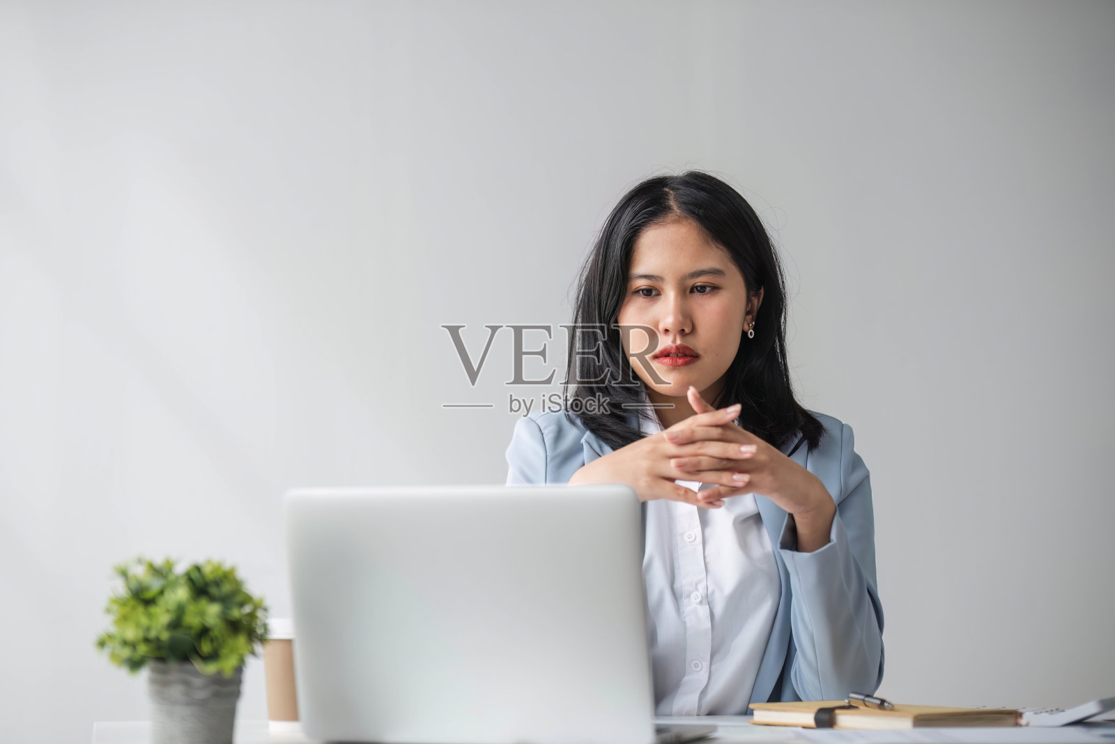 年轻微笑的亚洲女商人在公司办公室用笔记本电脑工作。快乐的职业女商人营销经理使用计算机技术照片摄影图片