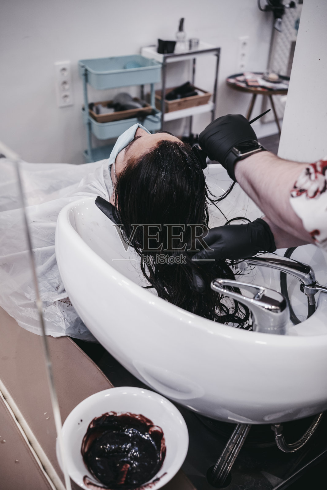 发型师与染发剂和染发剂刷在发廊照片摄影图片