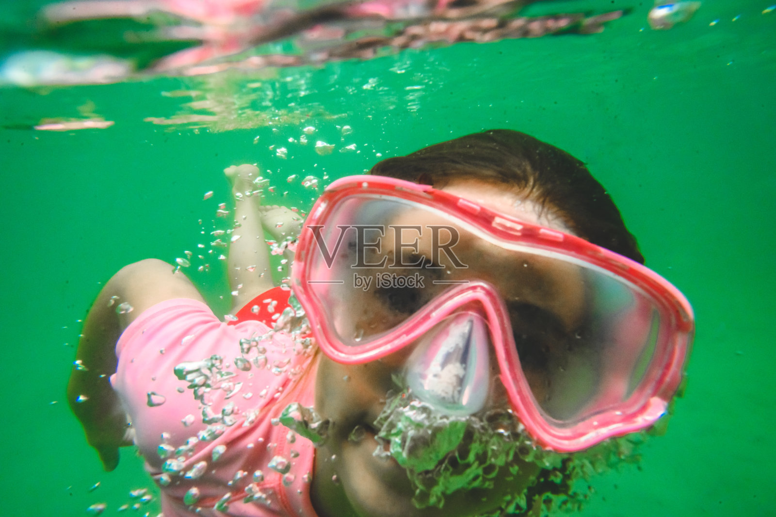 顽皮的游泳女孩戴着泳镜在水下游泳照片摄影图片