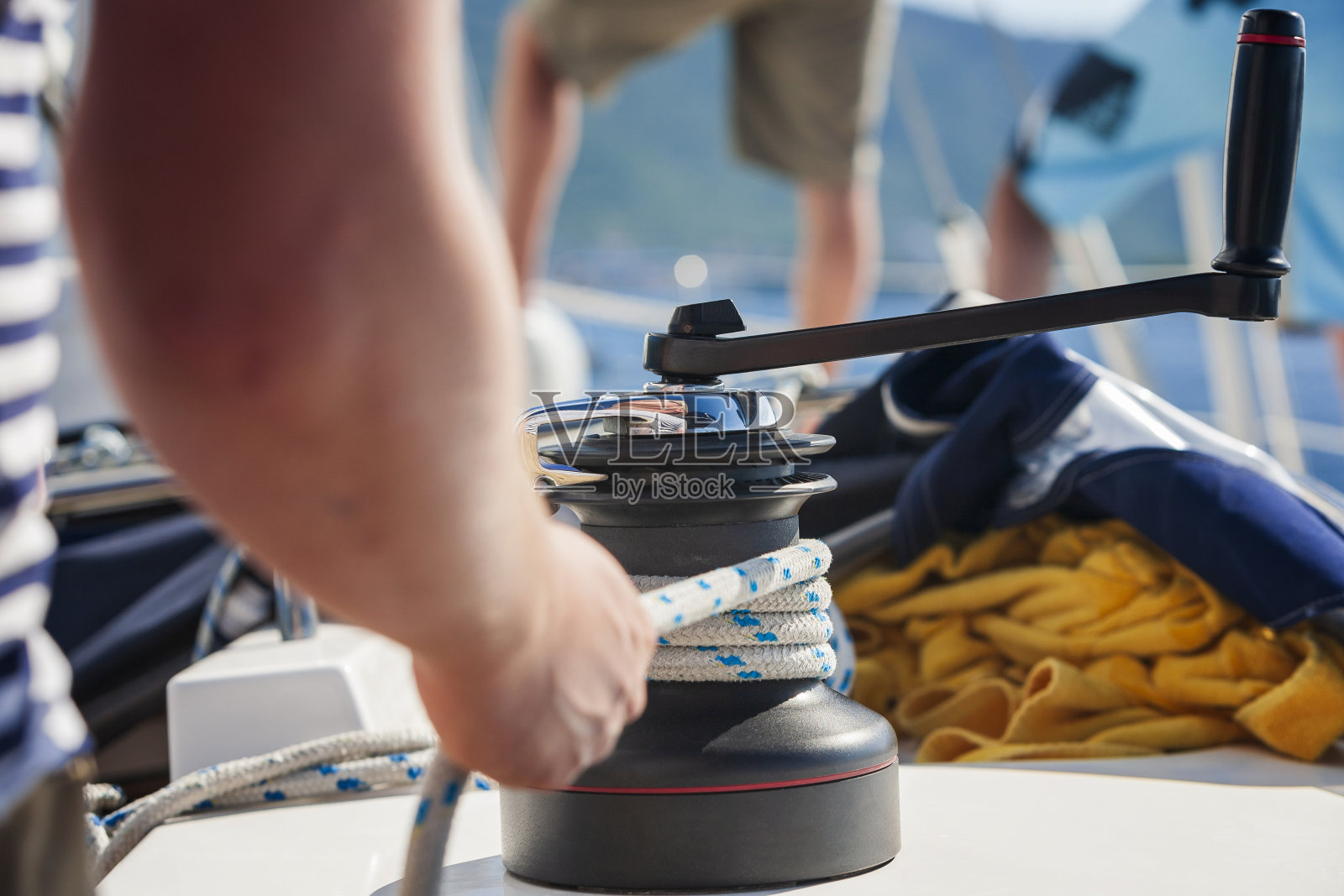 水手在绞车上用旋转手柄缠绕前帆绳照片摄影图片