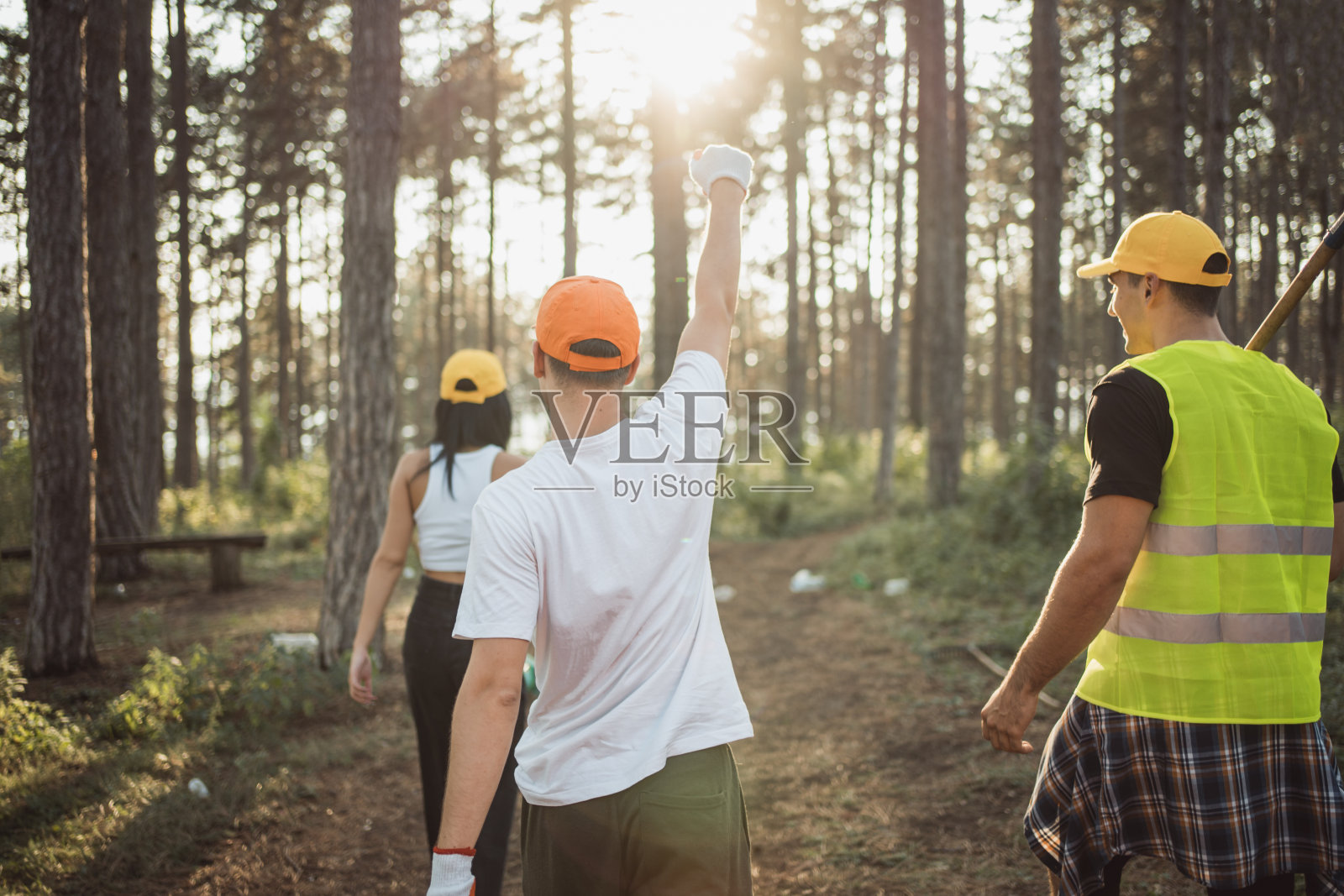 一群青少年通过从大自然中收集废物，共同为保护环境做出贡献。他们的行动表达了对环境的参与、责任和关心。照片摄影图片