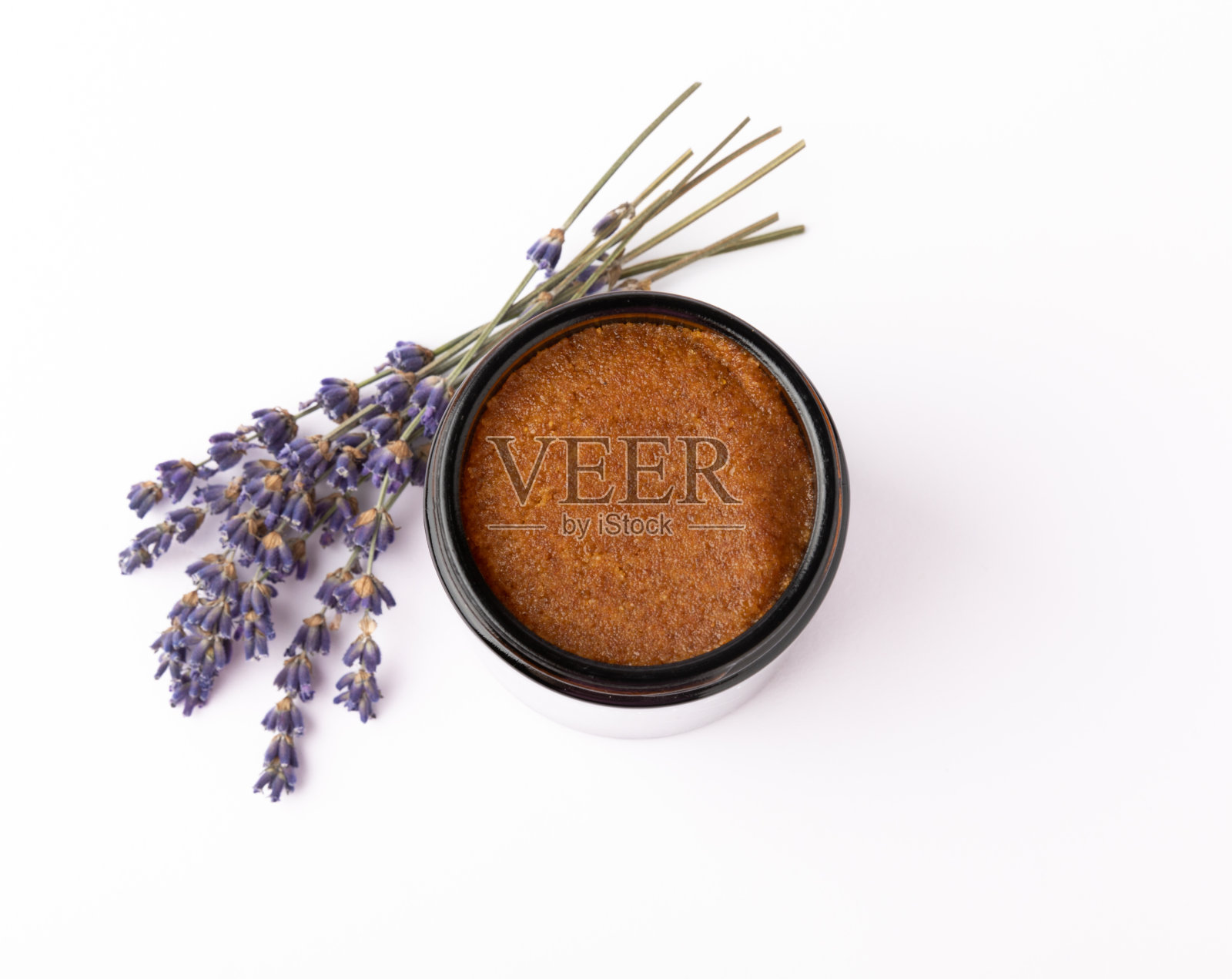 天然薰衣草磨砂膏隔离在白色背景。身体磨砂膏。身体保健。用摩洛哥坚果油和喜马拉雅盐磨砂糖。水疗中心设置照片摄影图片