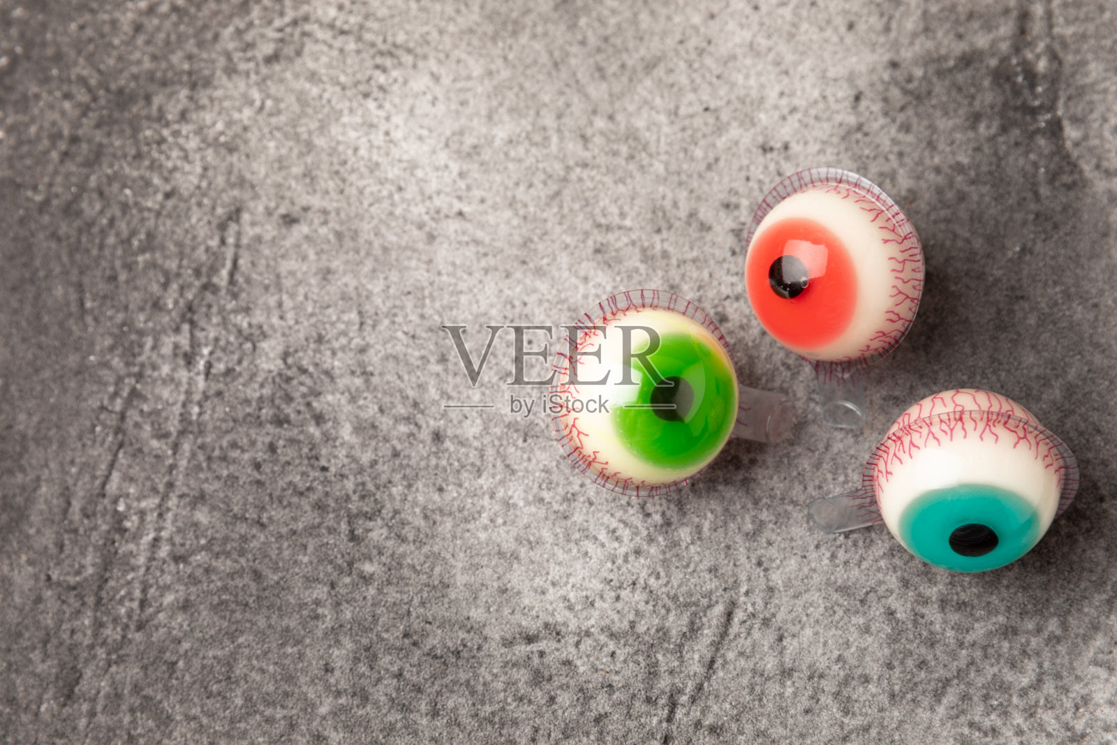 万圣节糖果玉米，果冻眼，南瓜糖，糖头骨在不同的碗背景。万圣节的经典糖果。万圣节的概念是玉米糖和南瓜灯。照片摄影图片