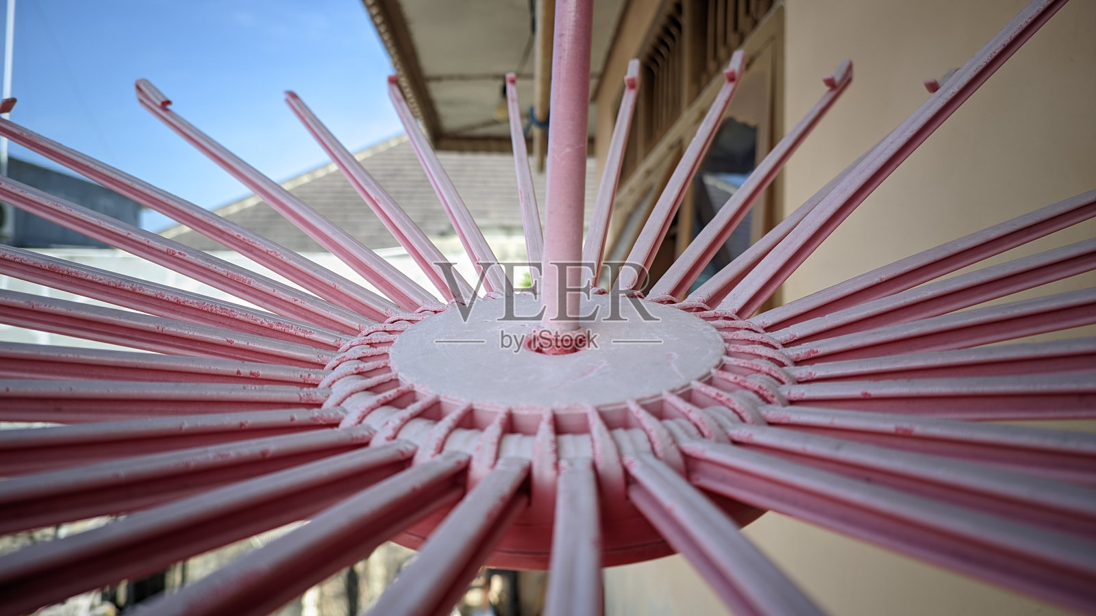 选择性聚焦一个圆形的粉红色衣架挂在晾衣绳上照片摄影图片