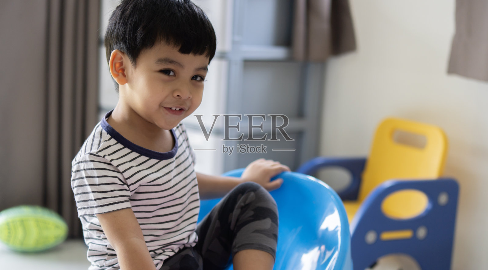 快乐的亚洲小男孩露出门牙，笑得很开心。照片摄影图片