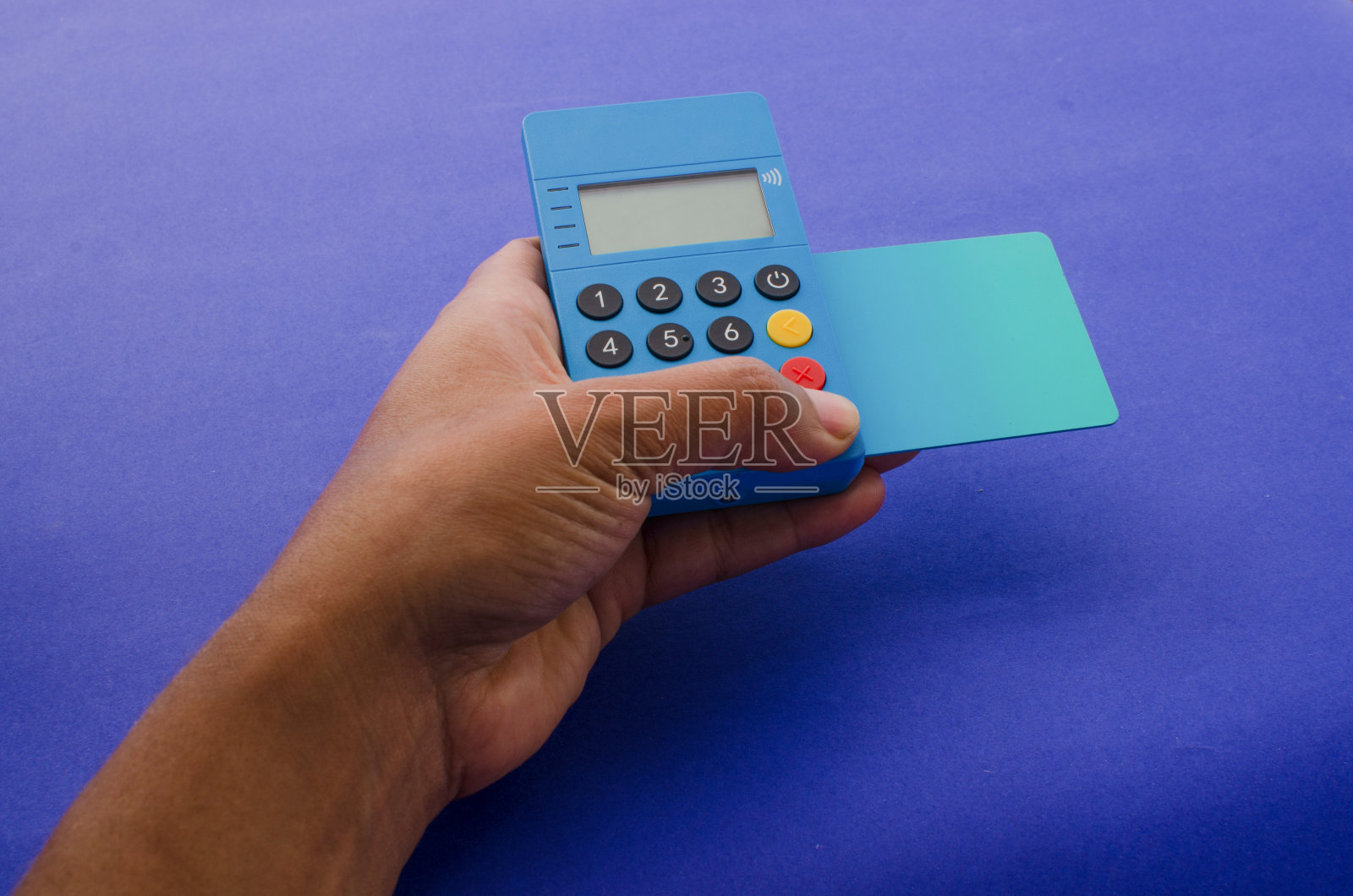 手持非接触式支付设备，设备旁放置超轻现代信用卡。金融支付概念，快速便捷交易的理想选择。照片摄影图片