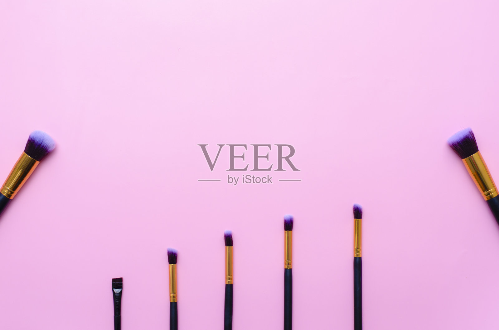 设置化妆刷在粉红色的背景与复制空间。前视图。壁纸照片摄影图片