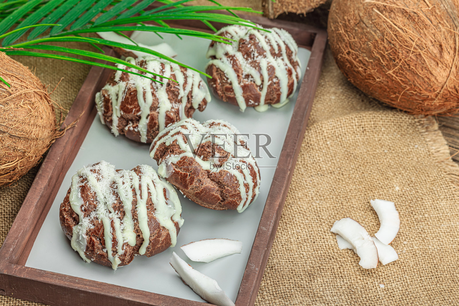 热带风味的泡芙酥皮面包配椰子奶油。棕榈叶照片摄影图片