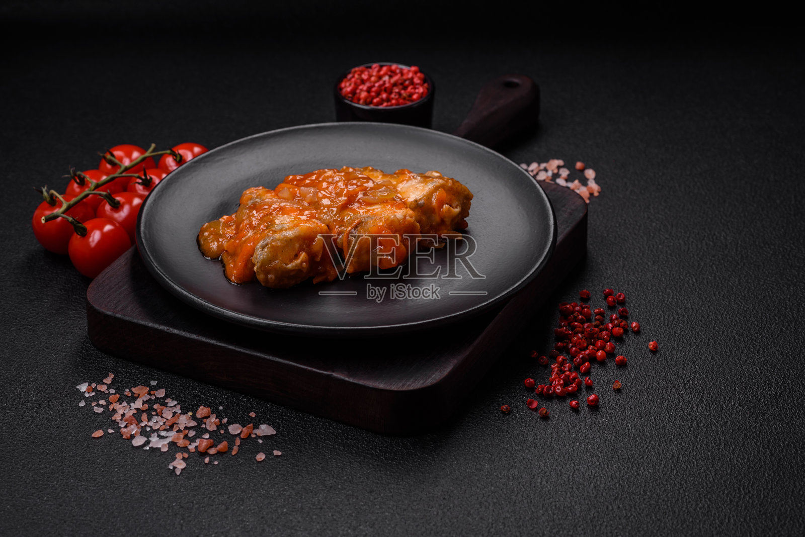 美味的新鲜海鱼切成块，用番茄酱烤熟照片摄影图片