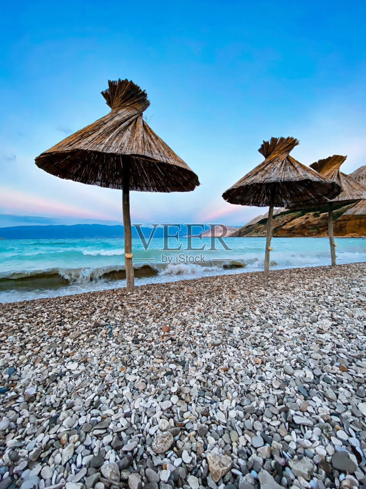 克罗地亚的专属海滩。美丽的日落在亚得里亚海，地中海。史诗般的山脉和岩石、悬崖、黄沙、海浪和绿松石般的水。自然景观，克尔克岛照片摄影图片