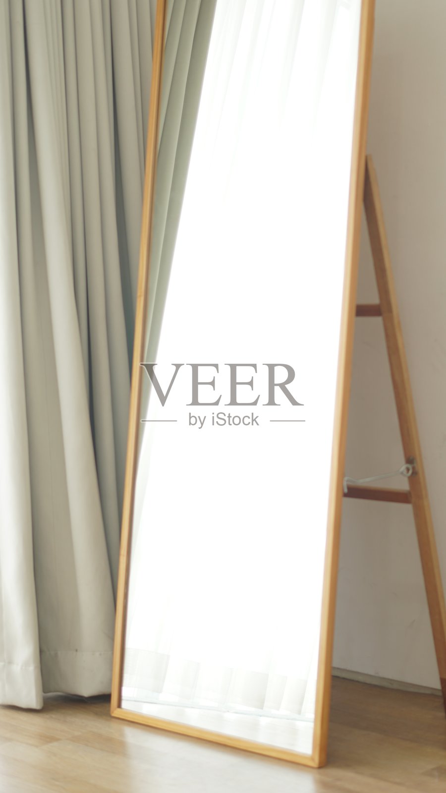 一面反射阳光的镜子和木地板营造出极简的感觉照片摄影图片