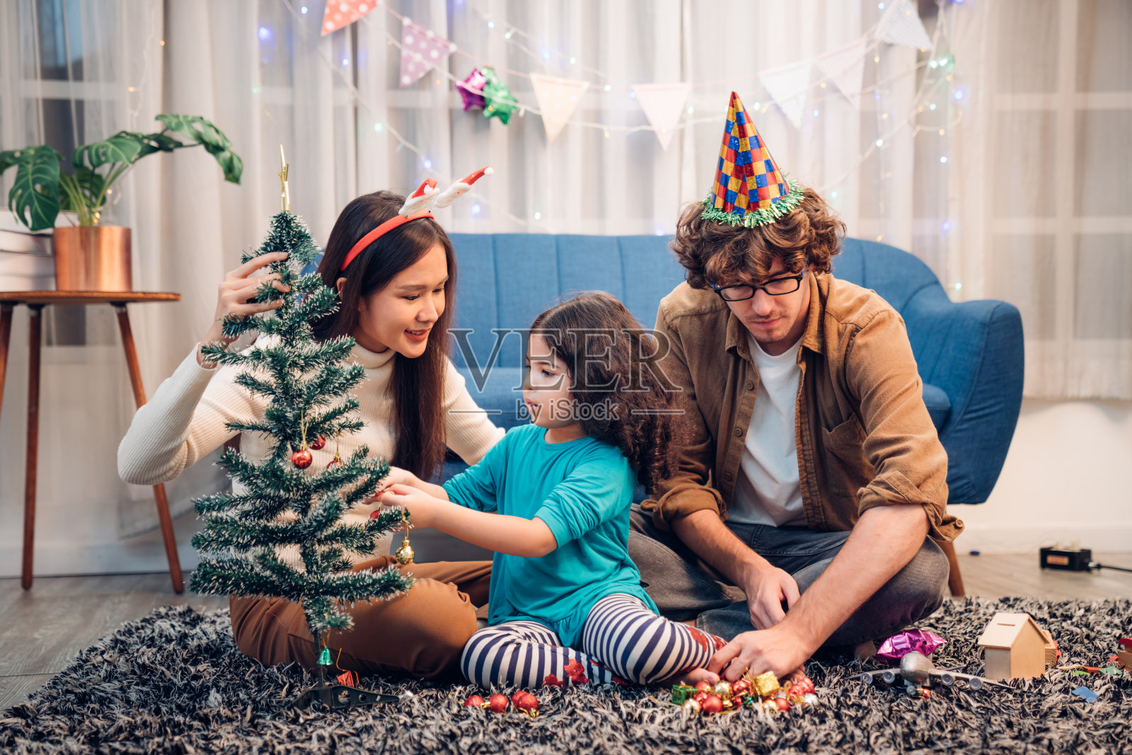 快乐可爱的爸爸、妈妈和孩子欢度圣诞和新年，点燃烟花。照片摄影图片