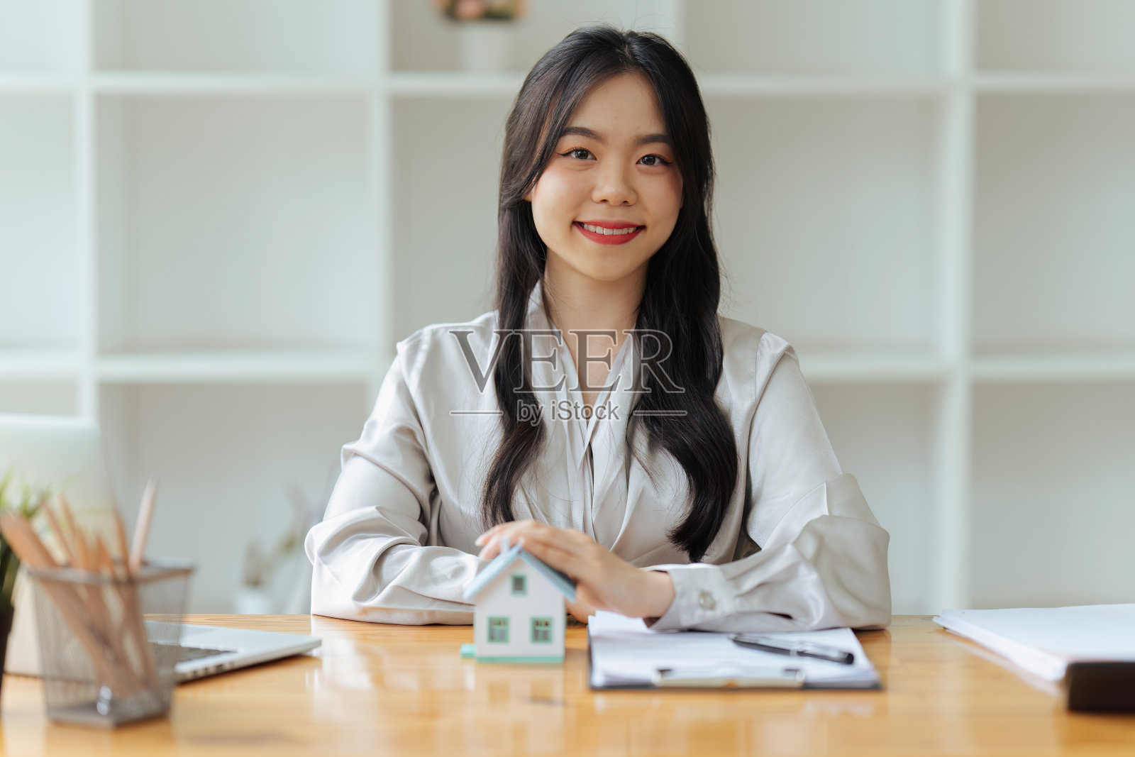 房地产经纪人向客户提出并咨询决策签订保险合同、房屋模型，有关按揭贷款报价和房屋保险。照片摄影图片