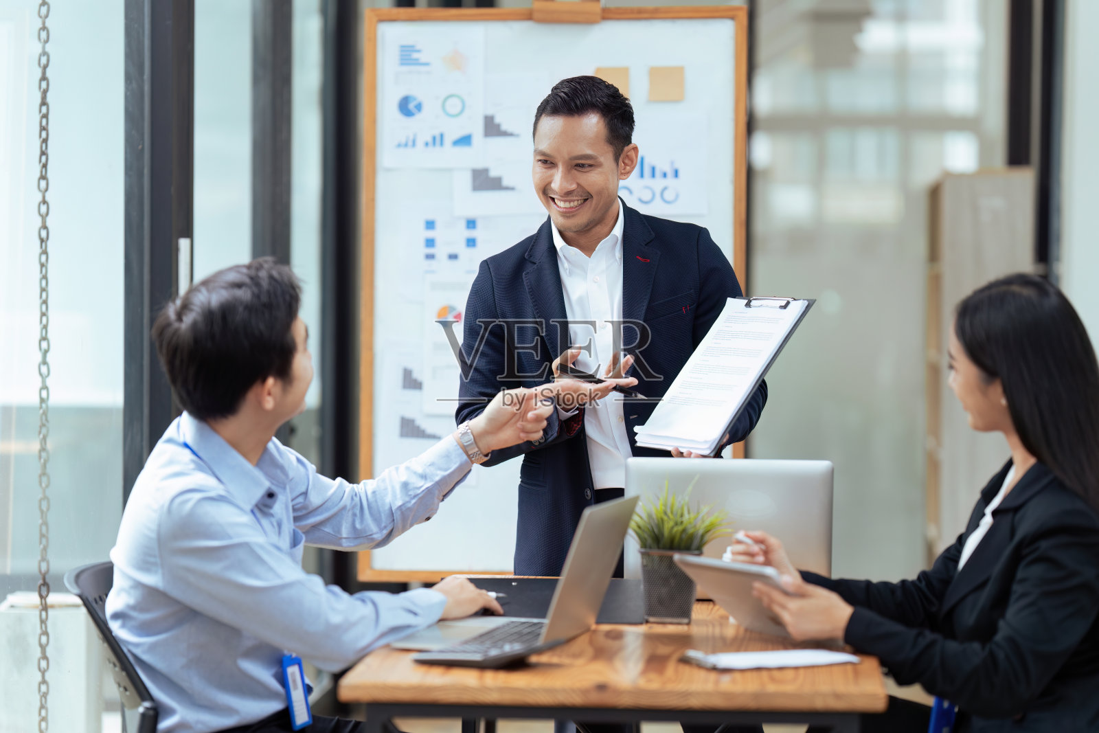 商务人士在办公室用平板电脑向公司同事展示战略计划照片摄影图片