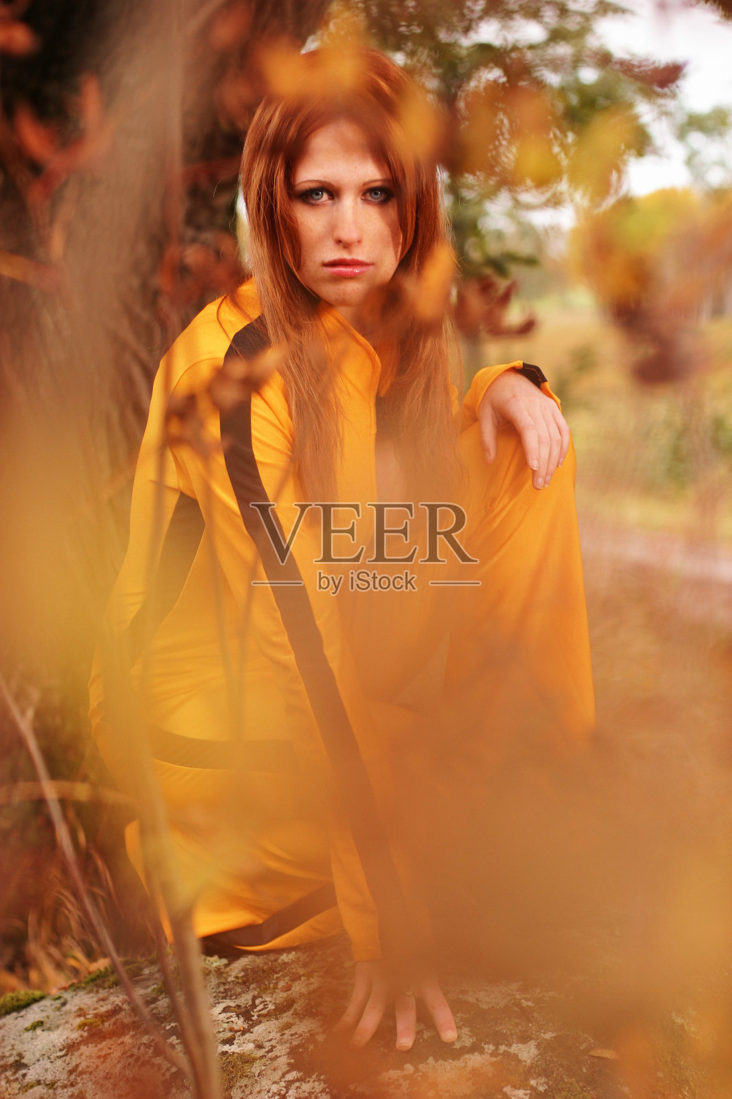 一个穿着运动服站在灌木丛后面的冒险女人照片摄影图片