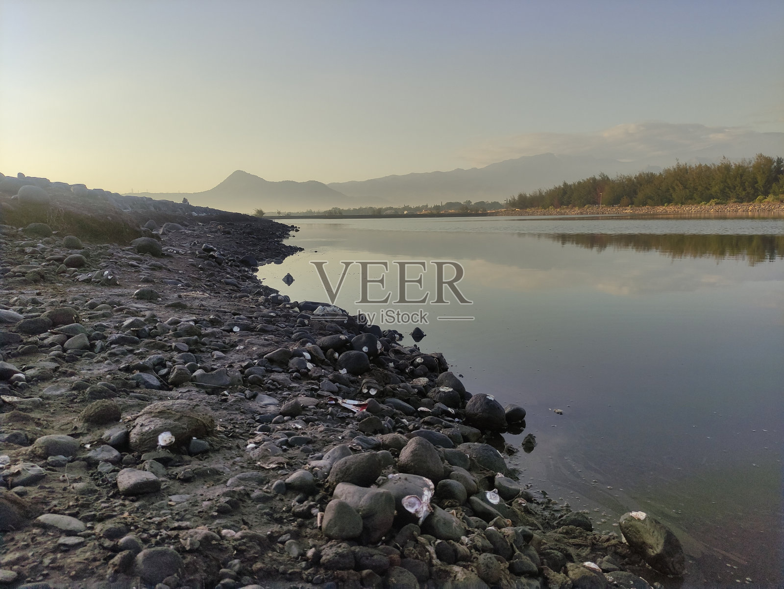 平静的海水适合海港，可欣赏海滨山丘的景色照片摄影图片