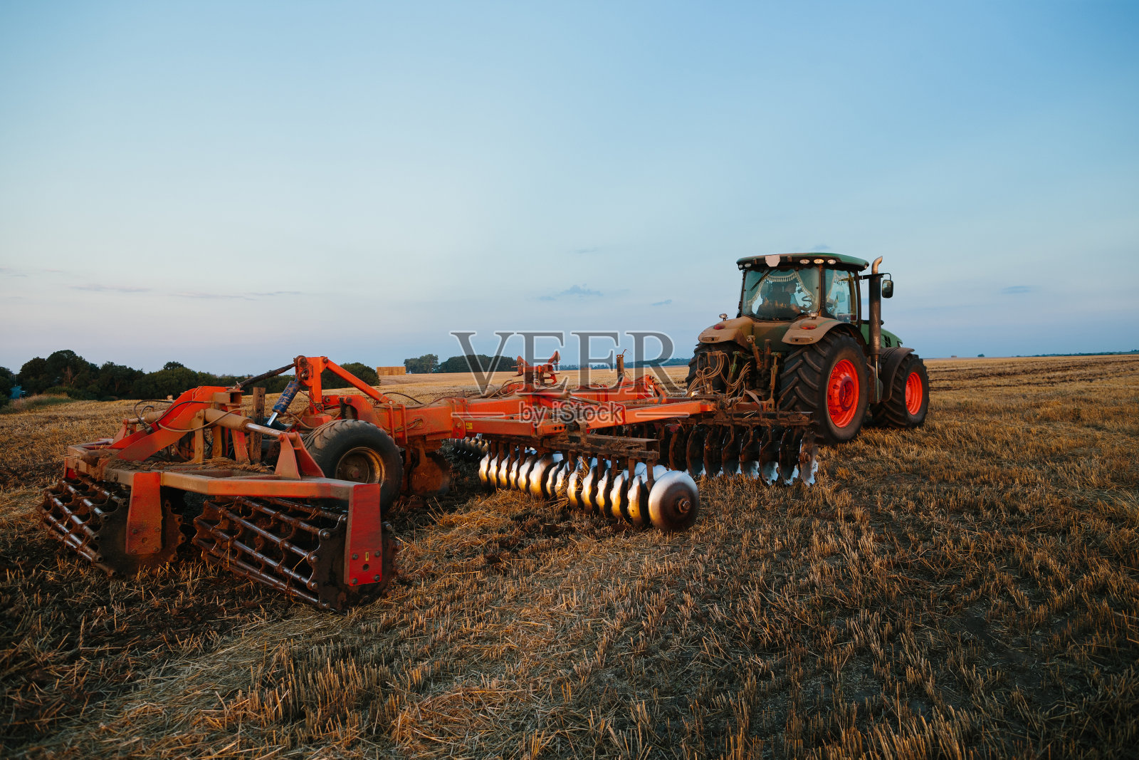 带大圆盘耙的拖拉机。农民劳动观念。照片摄影图片