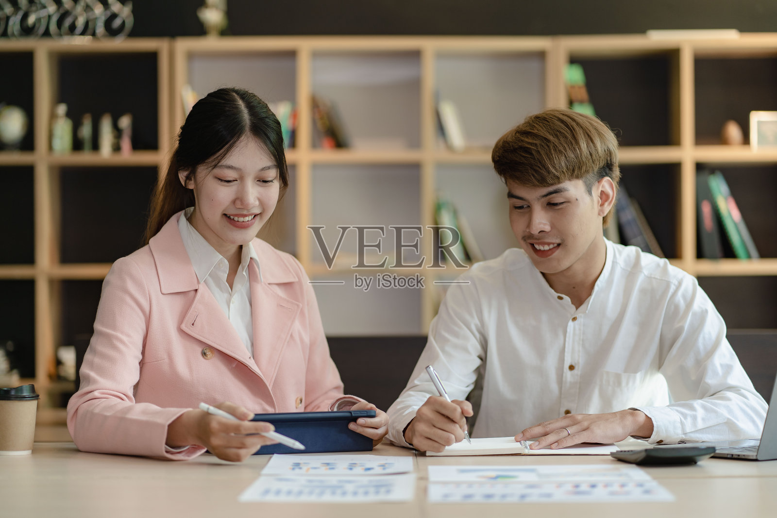 亚洲男性和女性与亚洲商业顾问在会议室用数码平板电脑分析和讨论财务报告情况。投资顾问，协作概念照片摄影图片