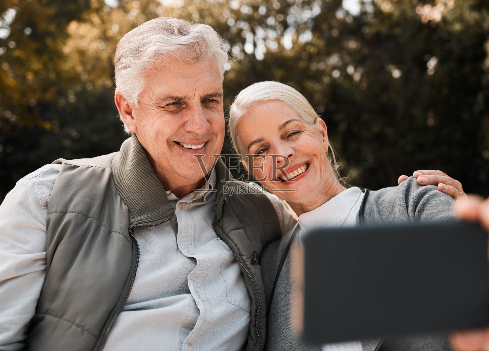 老年夫妇，户外徒步和微笑自拍，网络博客和大自然的记忆，阳光和冒险。老人、女人和社交媒体一起在树林里拍照和头像照片摄影图片