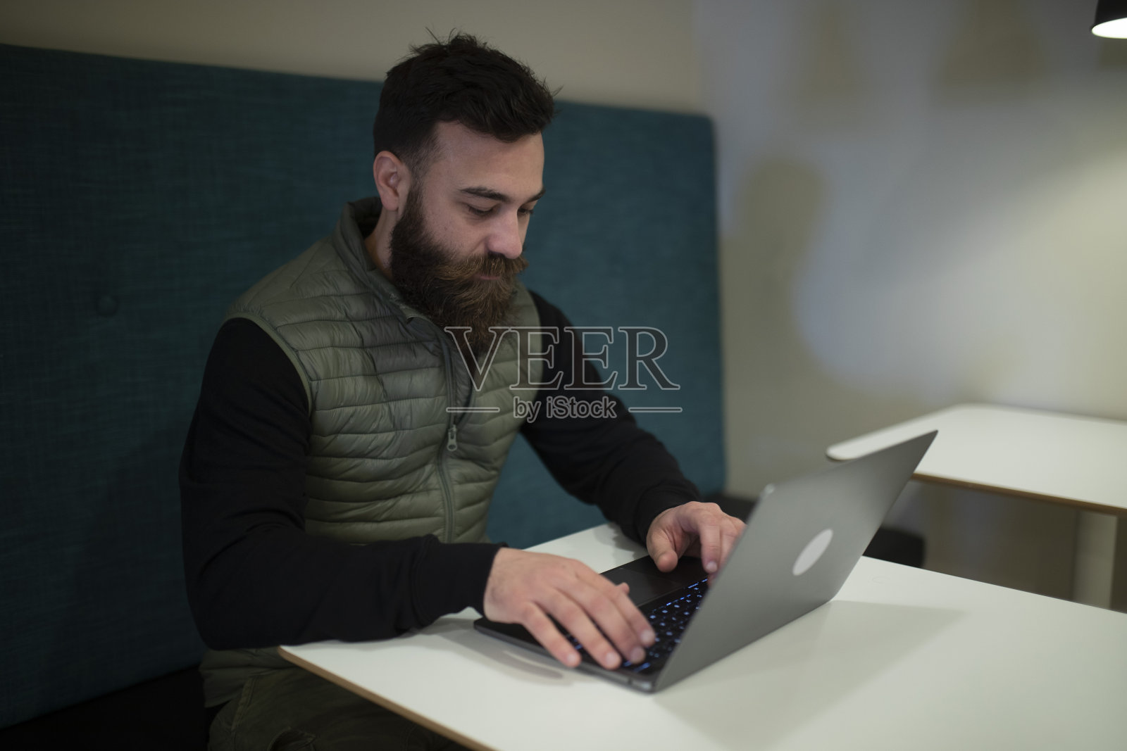 一名大胡子男子用笔记本电脑与同事进行在线会议。照片摄影图片