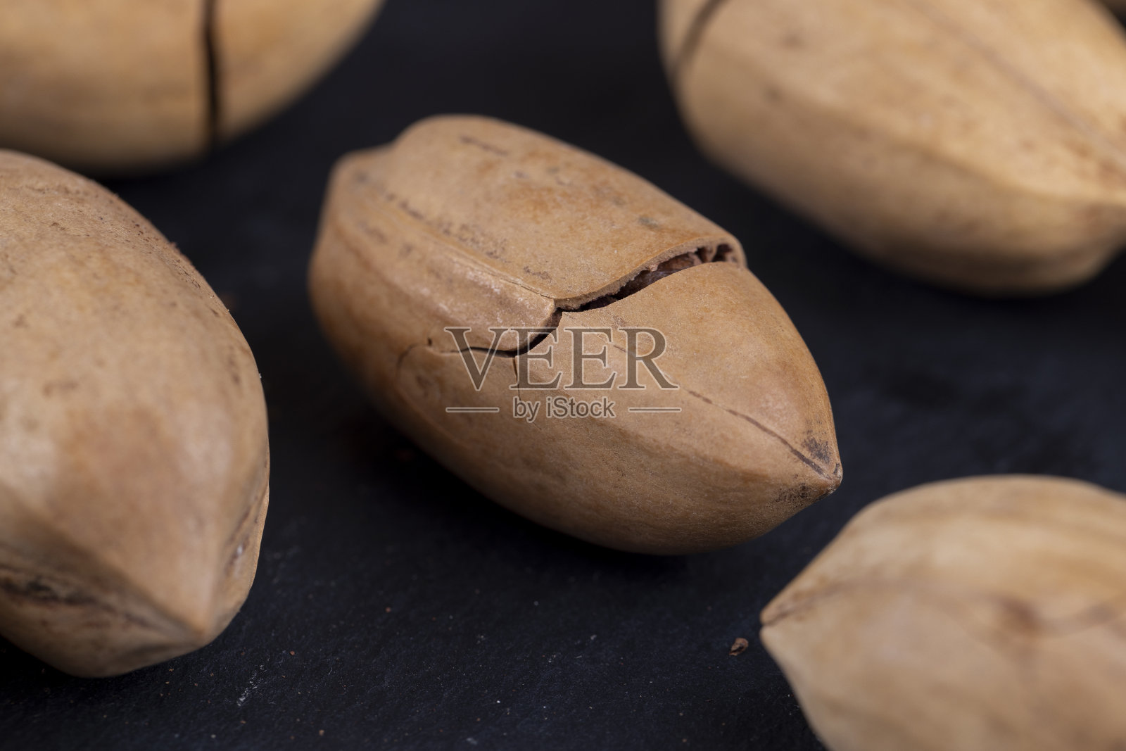 碎裂未剥皮的山核桃在桌子上的特写照片摄影图片